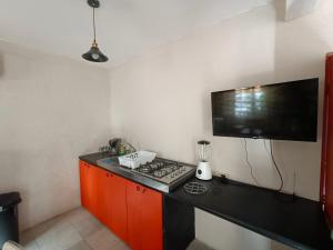 cocina con fogones y TV de pantalla plana. en casa agave en San José del Cabo