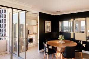 Un comedor con mesa y sillas en Milson Serviced Apartments, en Sídney