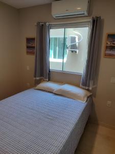 um pequeno quarto com uma cama com uma janela e uma cama quadrada em Lindo apartamento pé na areia em Cabo Gaibú prox Porto de galinhas em Cabo de Santo Agostinho