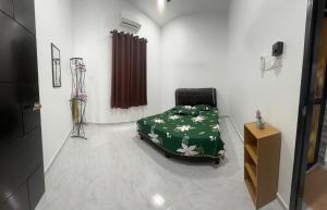 Un dormitorio con una cama con una manta verde con flores en Tokmabah Homestay, en Ketereh