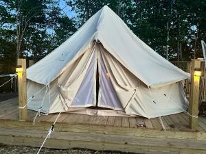 a large white tent on a wooden deck at 10 point landing Mammoth Cave Glamping Sublimity in Horse Cave