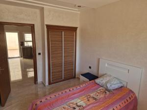 une chambre avec un lit et une porte coulissante en verre dans l'établissement Appartement saidia 3 chambre à 150 m de la plage, à Saïdia