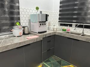 a kitchen with a counter top with a coffee maker at Tokmabah Homestay in Ketereh