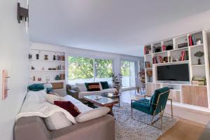 ein Wohnzimmer mit einem Sofa und einem TV in der Unterkunft CHATOU - Luxury close Paris La défense Arena - 2 bedrooms- fully renovated in Chatou