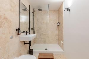 a bathroom with a sink and a tub and a toilet at Chic 1BD Maisonette wHot Tub King's Cross! in London