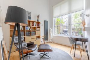 a living room with a lamp and a chair at Chic 1BD Maisonette wHot Tub King's Cross! in London