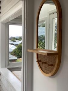 un espejo cuelga en una pared junto a una ventana en Driftwood Sorrento beach house, en Sorrento