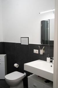 une salle de bain avec des toilettes blanches et un lavabo dans l'établissement MONOLOCALE STUDIO Zia Make, à Marinella