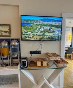 a counter with bread and a tv on a wall at Aparthotel in orbi in Batumi