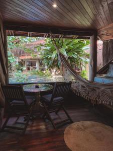 a hammock in a room with two chairs and a table at Pousada Sage Point in Itacaré
