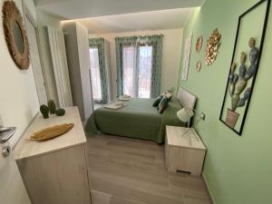 Schlafzimmer mit einem Bett mit grüner Tagesdecke in der Unterkunft La Terrazza del Capo in San Vito lo Capo