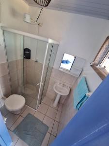 ein Bad mit einer Dusche, einem WC und einem Waschbecken in der Unterkunft Pousada Kahuna Farol in Laguna