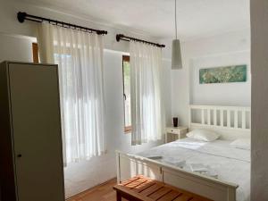 1 dormitorio con cama blanca y ventana en Tsira Taş Otel en Döşeme