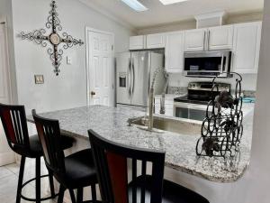 a kitchen with a counter with chairs and a refrigerator at Home Away from Home in Bluffton
