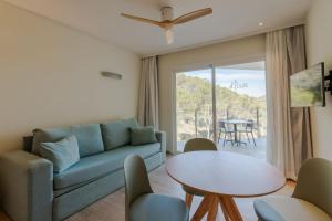 - un salon avec un canapé et une table dans l'établissement Hotel El Pinar, à Cala Llonga