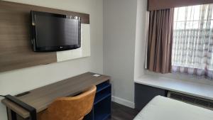 a room with a desk and a tv on a wall at Quality Inn & Suites in Santa Rosa