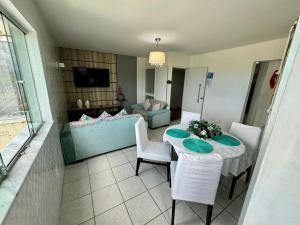 a living room with a table and a couch at Beira-mar na praia pajuçara Dois quartos - Apto 302 in Maceió