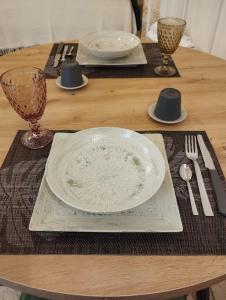 a wooden table with a plate and two glasses on it at Ziella Home in Ostuni +14 photos