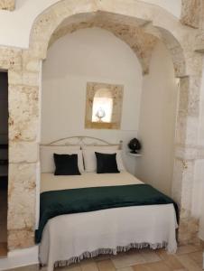 a bedroom with a white bed with black pillows at Ziella Home in Ostuni