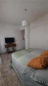 um quarto com uma cama e uma televisão de ecrã plano em departamento tandil em Tandil