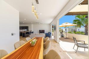 a dining room and living room with a wooden table and chairs at Cabo Villa - G3 Punta Arena - 3 Bed 2.5 Bath in Cabo San Lucas