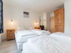 a hotel room with three beds and a desk at Brixen 3 in Brixen im Thale