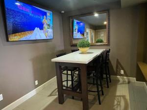 un bar en un cine en casa con TV en la pared en Quality Inn Ontario Airport Convention Center, en Ontario