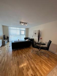a living room with a black couch and a table at Cardiff City Center - with FREE Parking in Cardiff
