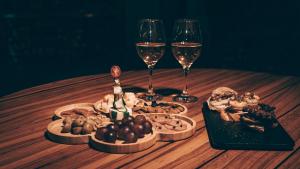 - une table en bois avec deux verres de vin et de nourriture dans l'établissement Hostería del Parque, à Machalilla