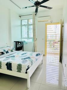 a white bedroom with a bed and a window at Spice Arena Service Apartment in Bayan Lepas
