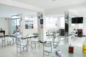 a restaurant with tables and chairs and a tv at Hotel Venture in Chincha Alta