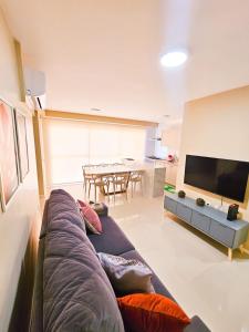uma sala de estar com um sofá e uma televisão de ecrã plano em Apartamento 3 quartos - Setor Coimbra em Goiânia
