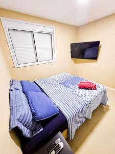 Dormitorio pequeño con cama y ventana en Apartamento 3 quartos - Setor Coimbra en Goiânia
