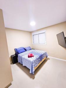 1 dormitorio con 1 cama con 2 almohadas rojas en Apartamento 3 quartos - Setor Coimbra en Goiânia