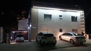 zwei nachts vor einem Gebäude geparkt in der Unterkunft Condomínio Pickler in Juquei