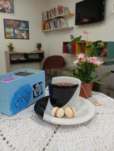 Una taza de café y dos galletas en una mesa. en CASA Próx Shopping Norte Londrina 2Qts Ar e CamaKing e Espacokids en Londrina