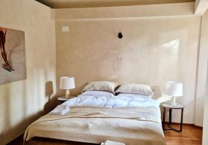 ein Schlafzimmer mit einem großen Bett mit zwei Lampen in der Unterkunft Suite Atelier Arringo in Ascoli Piceno