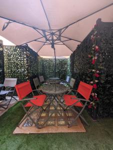 eine Terrasse mit einem Tisch und Stühlen unter einem Sonnenschirm in der Unterkunft Benedict Rooms in Bologna