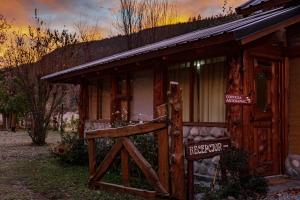 una cabaña antigua con una puerta de madera delante de ella en Cabañas Patagonia Rupestre en El Bolsón