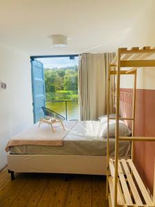 a bedroom with a bunk bed and a window at Vila Eco Mobili in São Roque