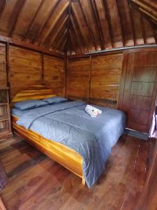 a bedroom with a bed in a wooden room at MY HOME tetebatu in Tetebatu
