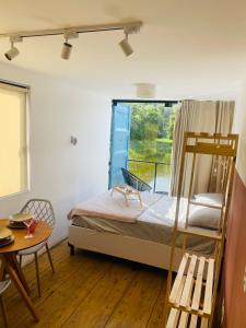 a bedroom with a bunk bed and a table at Vila Eco Mobili in São Roque