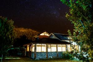 una casa bajo un cielo estrellado por la noche en Cabañas Patagonia Rupestre en El Bolsón