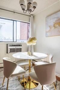 a white dining room with a table and chairs at Apt in West New York free Parking 15 Min to Times Square in West New York