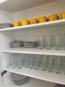a shelf filled with empty glasses and plates at Hospedagem Dona Ester in Pomerode