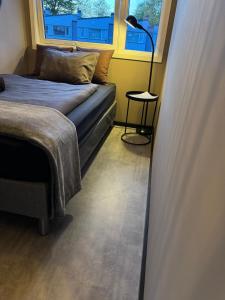 - une chambre avec un lit et une lampe à côté d'une fenêtre dans l'établissement Private room in Hundvåg, à Stavanger