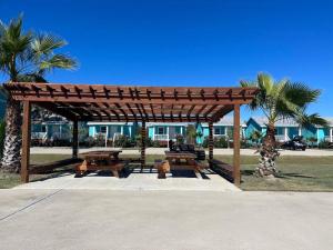 un pavillon en bois avec des tables de pique-nique et des palmiers dans l'établissement Horizon Cottage #5, à Rockport