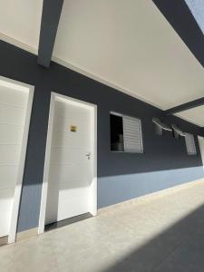 um quarto com duas portas brancas e uma parede em Kitnet Luz do Mar em Maringá