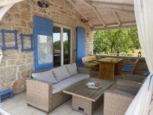 a patio with a couch and a table on a building at Holiday house with a swimming pool Puljane, Krka - 23038 in Drniš