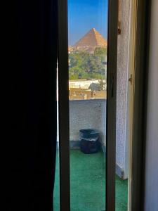 an open door with a view of a pyramid at Three pyramids view INN in Cairo